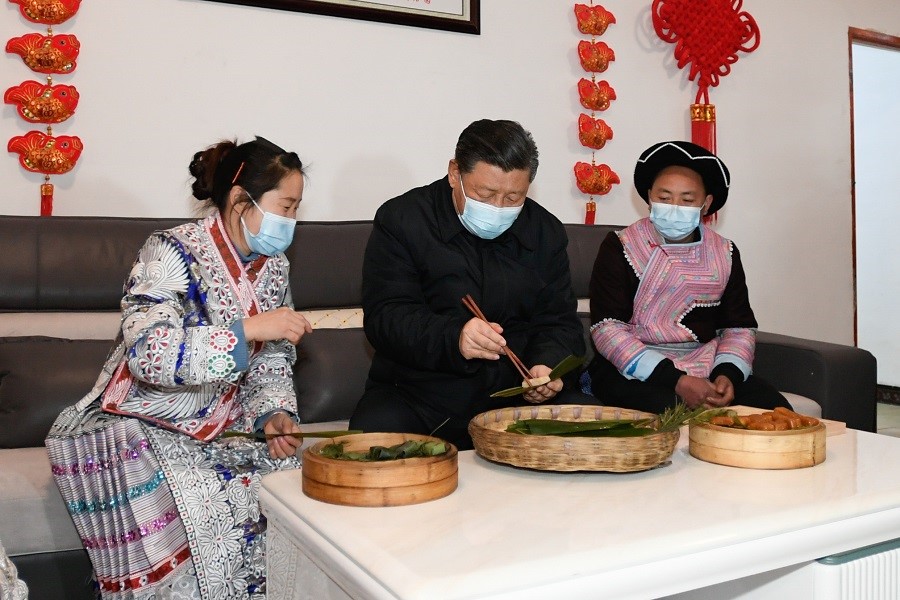 2021年2月3日下午，習近平在貴州畢節(jié)市黔西縣新仁苗族鄉(xiāng)化屋村苗族村民趙玉學家，同一家人邊聊家常邊制作當地傳統節(jié)日食品黃粑。新華社記者 李學仁 攝