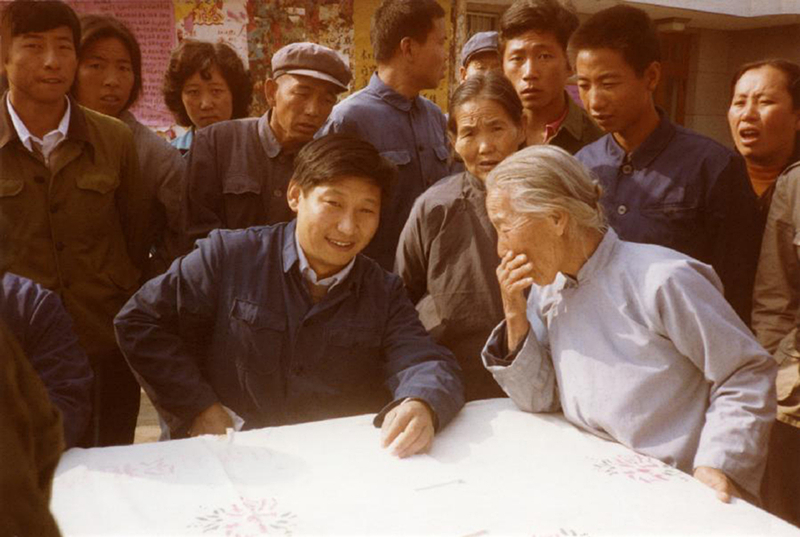 1983年，時(shí)任河北正定縣委書記的習(xí)近平（前排居中），臨時(shí)在大街上擺桌子聽(tīng)取老百姓意見(jiàn)。